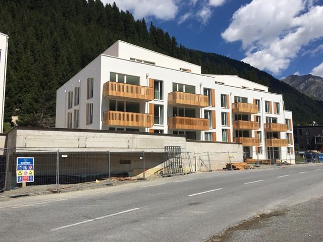 Ein Gebäude mit vielen Balkonen und Bergen im Hintergrund