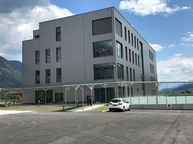 Ein weißes Auto steht vor einem großen Gebäude