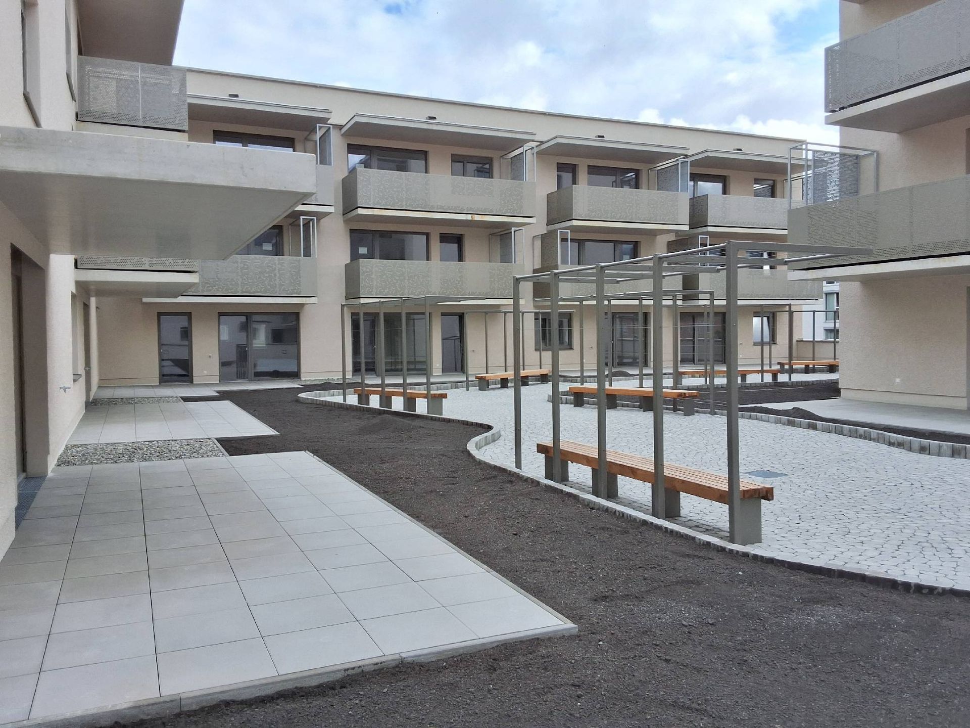 Ein Gebäude mit vielen Balkonen und Bänken