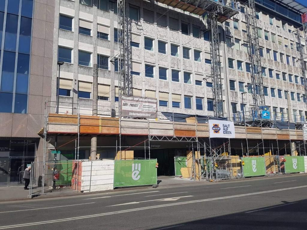 Am Straßenrand wird derzeit ein großes Gebäude errichtet.