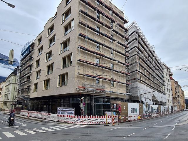 An der Ecke einer Stadtstraße wird ein großes Gebäude gebaut.