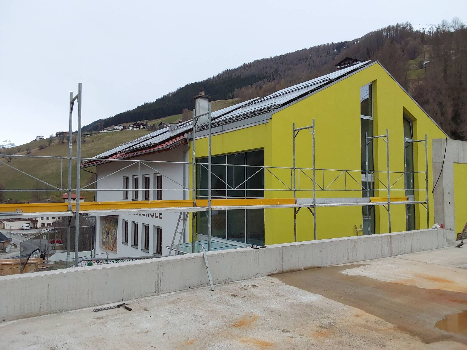 Ein gelbes Gebäude im Bau mit Gerüsten drumherum