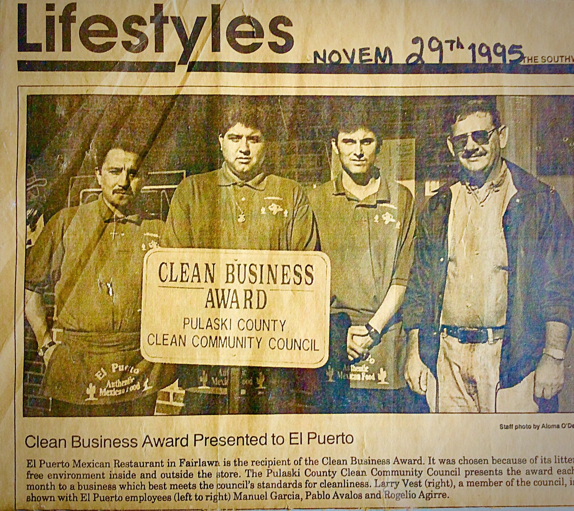 Newspaper clipping of four men holding a 