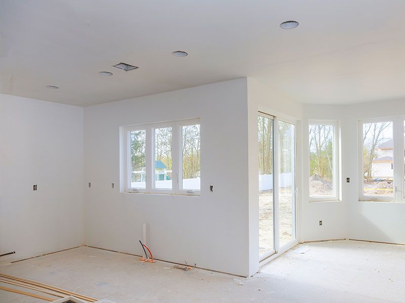 An empty room with white walls and sliding glass doors.