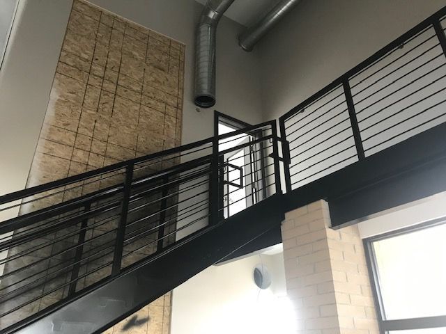 A staircase with a metal railing leading up to the second floor of a building.