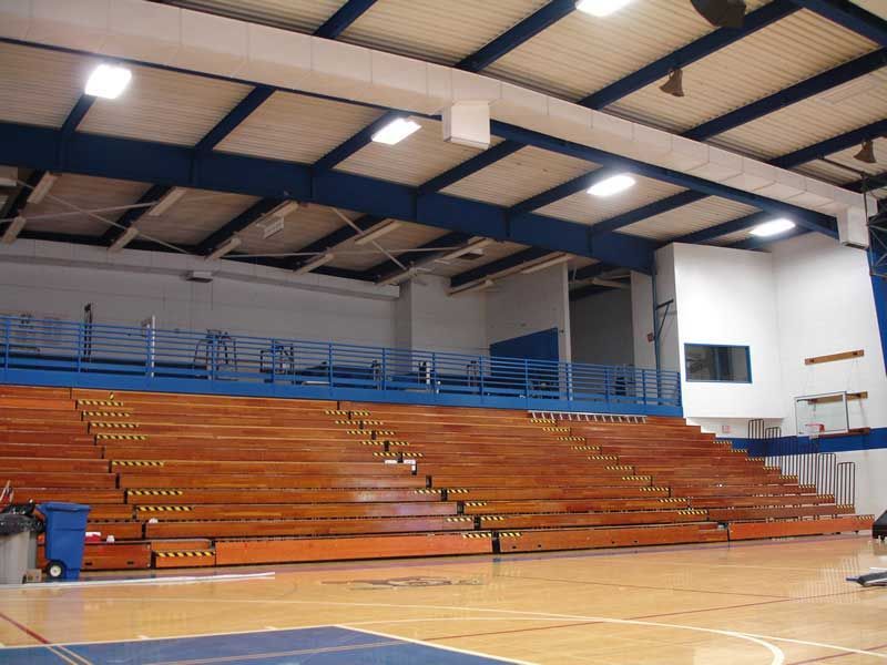 An empty gym with bleachers and a basketball court