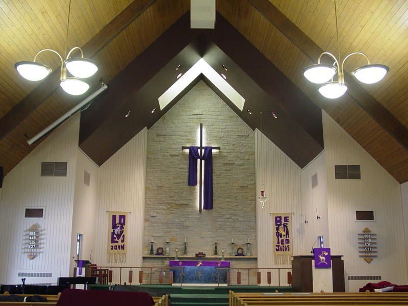 The inside of a church with a cross on the altar