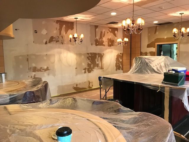 A room that is being remodeled with tables and a chandelier.