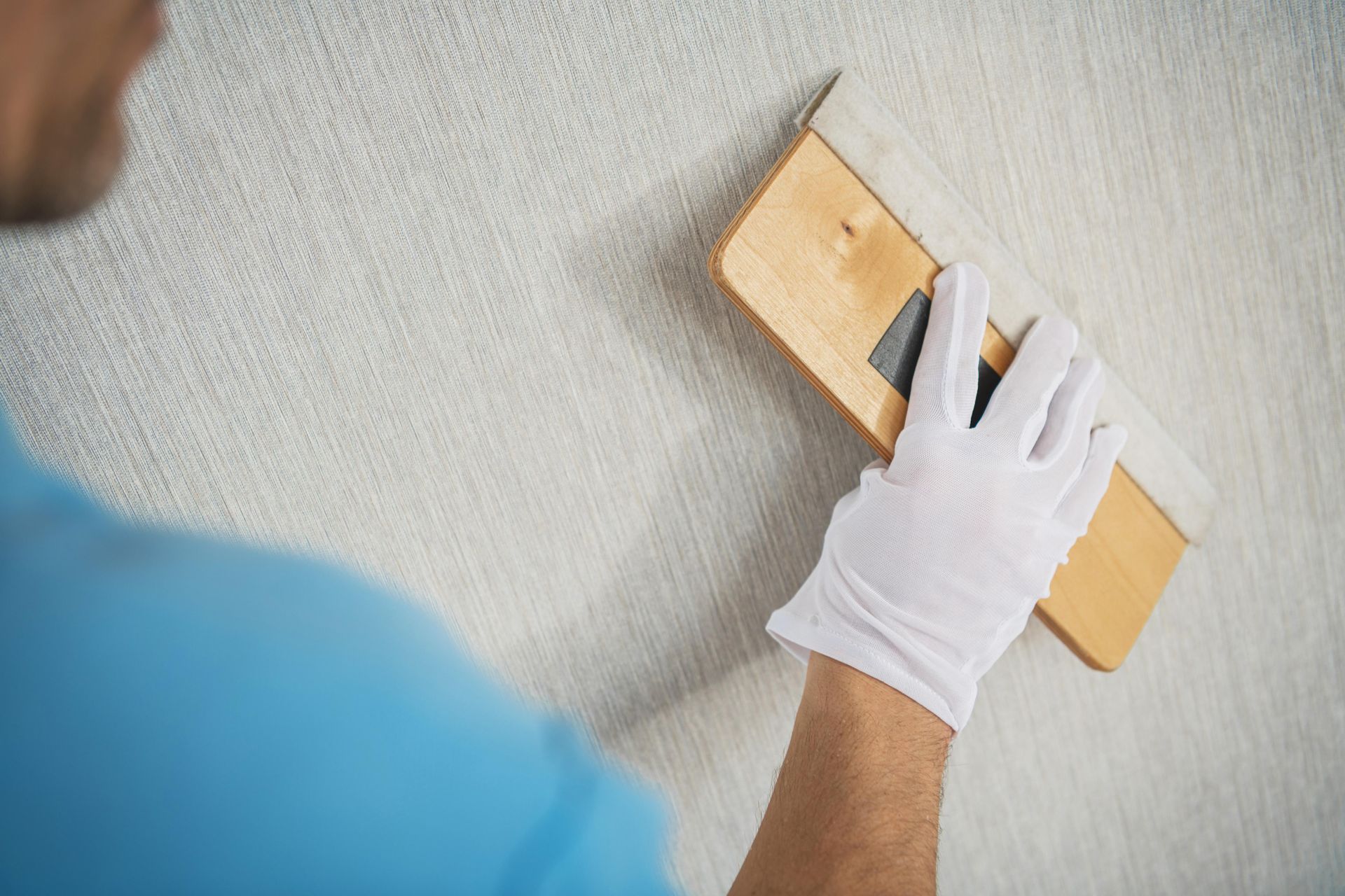 A man is painting a wall with a spatula.