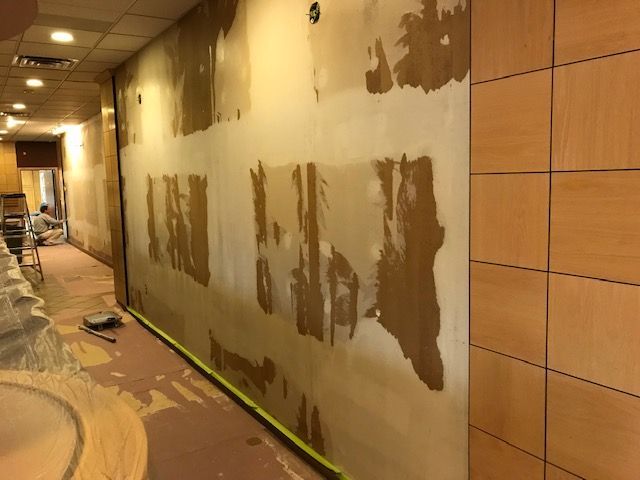 A hallway with a wall that is being painted