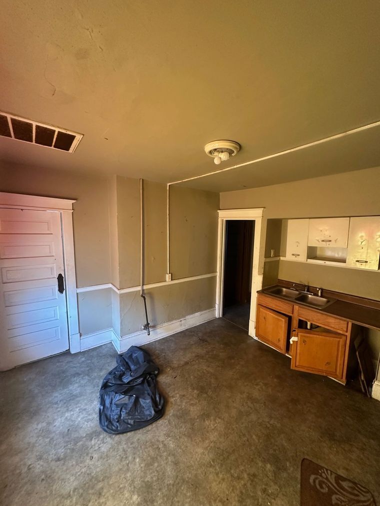 An empty room with a sink and cabinets in it.