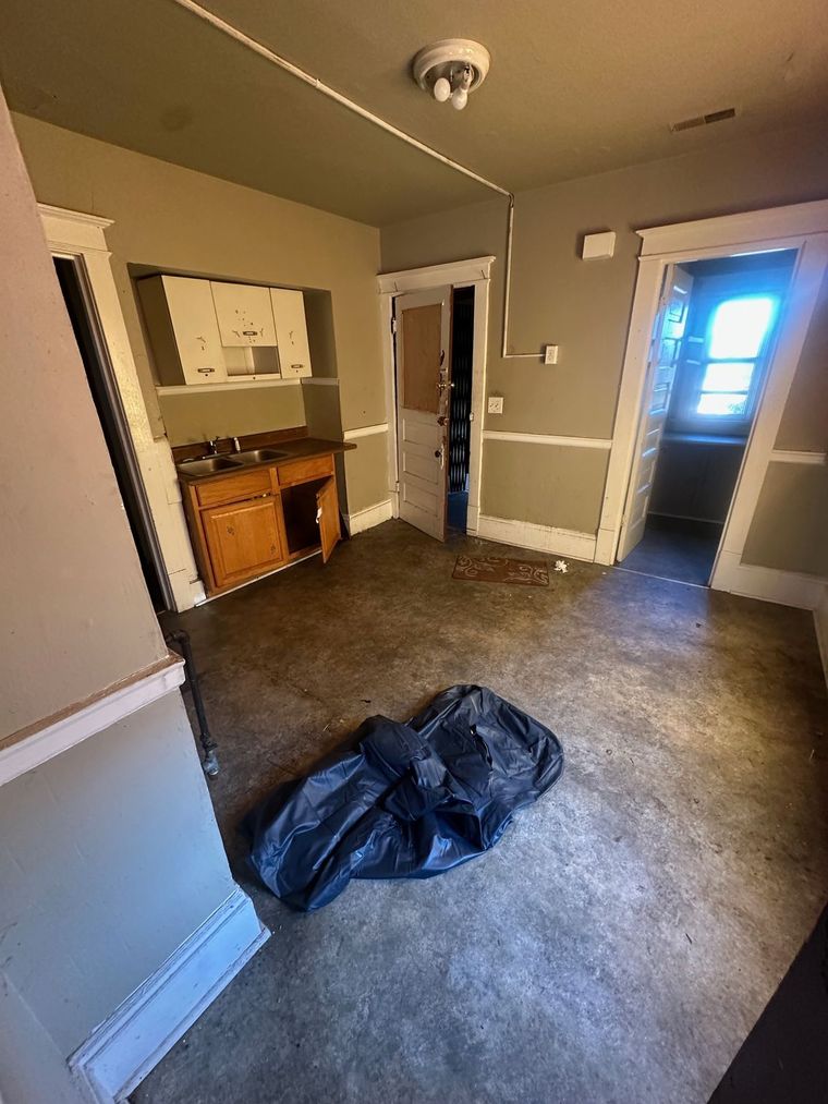 An empty room with a black tarp on the floor.