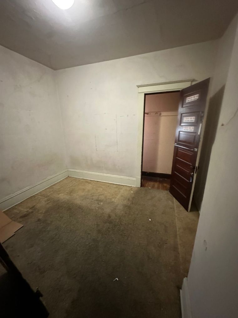 An empty room with a door open to a closet.