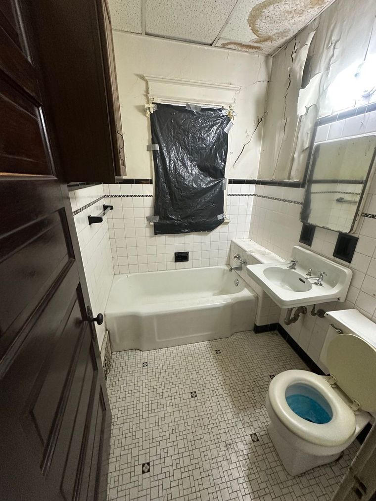 A bathroom with a toilet a sink and a bathtub