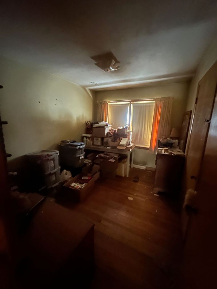 A room with a lot of boxes on the floor and a window.