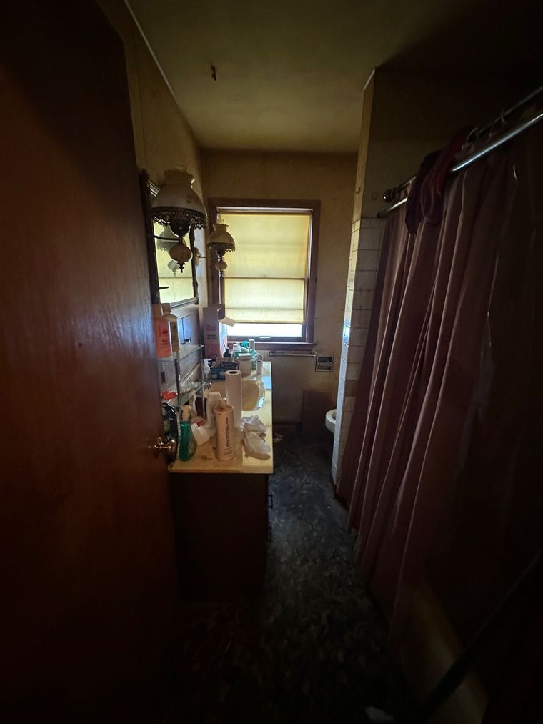 A bathroom with a sink , toilet , mirror and shower curtain.