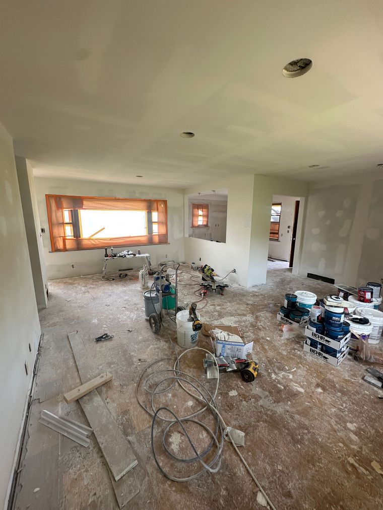 A living room is being remodeled with a lot of tools on the floor.