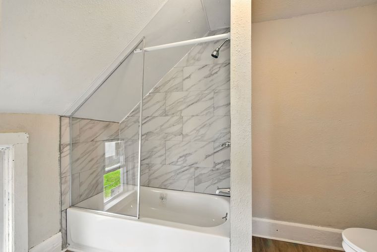 A bathroom with a bathtub and a toilet.