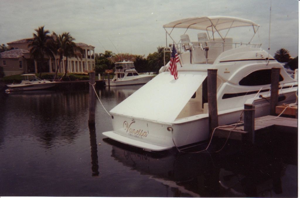 A white boat is docked at a dock with the name nirvana on the back