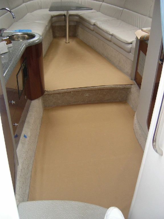 The inside of a boat with a couch and a sink