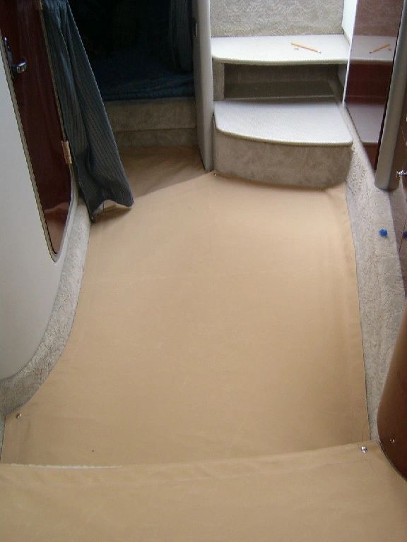 A room with stairs and a rug on the floor.