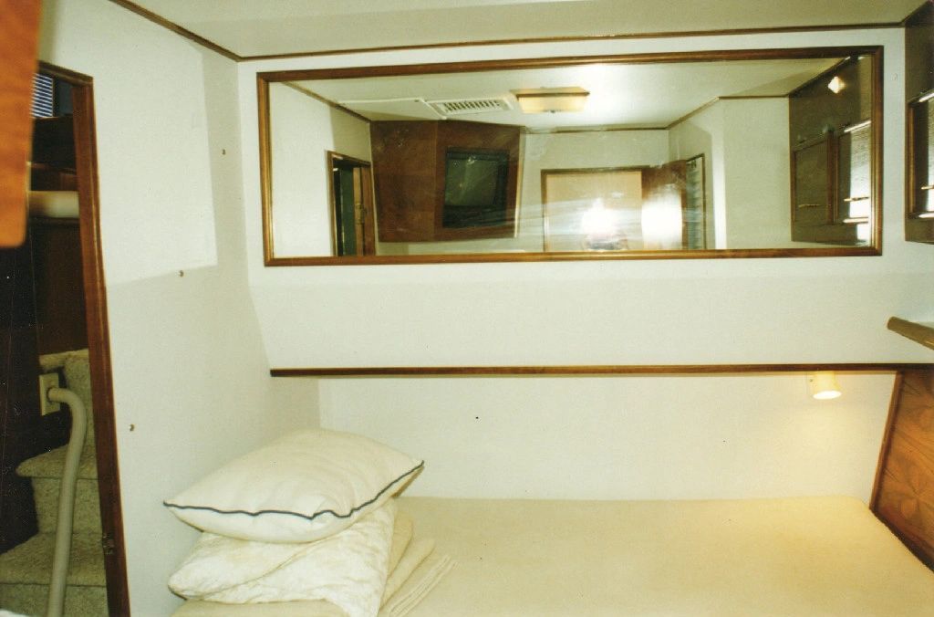 A bedroom with a bed and a large mirror
