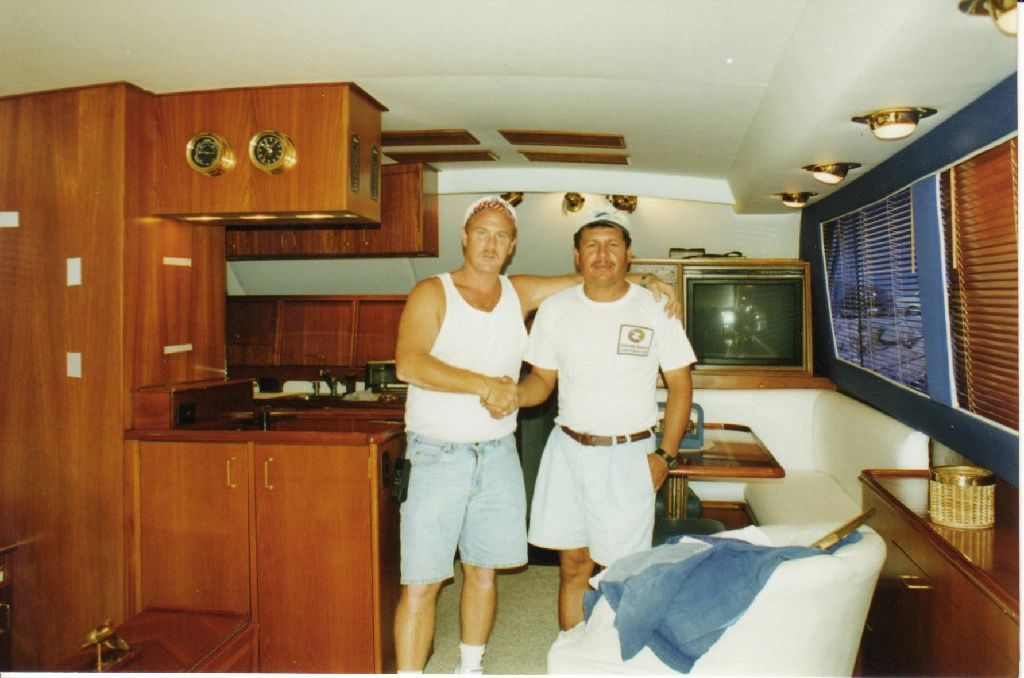 Two men shaking hands in a room with a tv