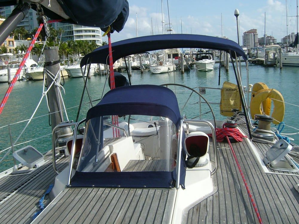 A boat with a blue canopy is docked in a marina