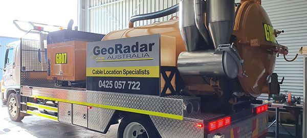 A vacuum truck is parked in a garage.