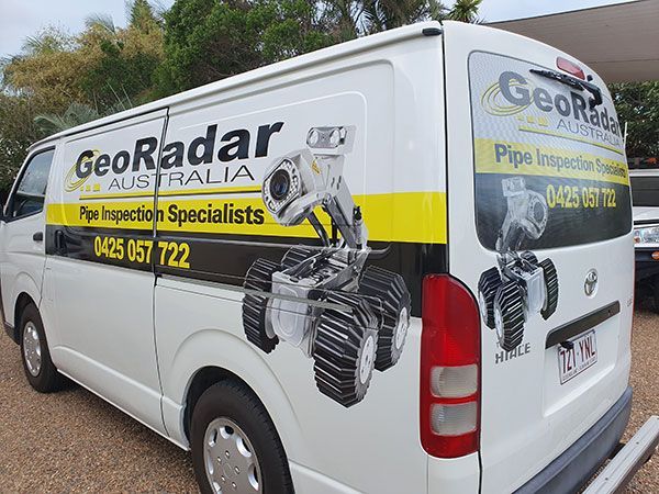 A white van with a yellow and black advertisement for geo radar australia