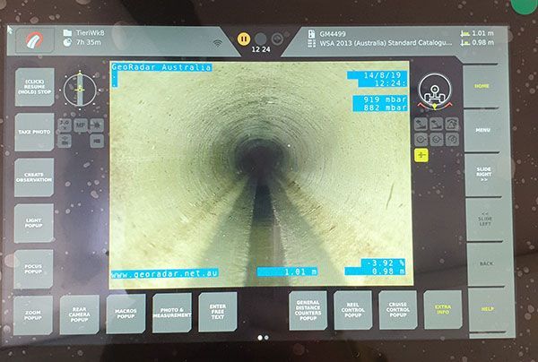 A computer monitor shows a picture of a tunnel with the time 12:34