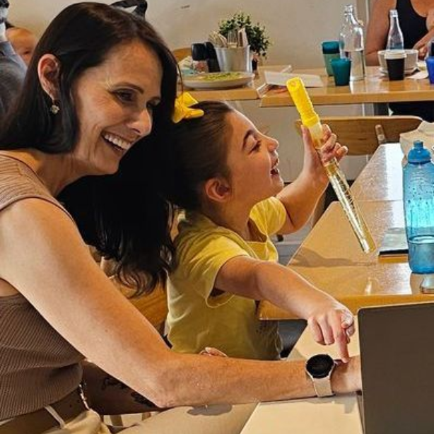 Four men are sitting on a bench with their arms crossed.