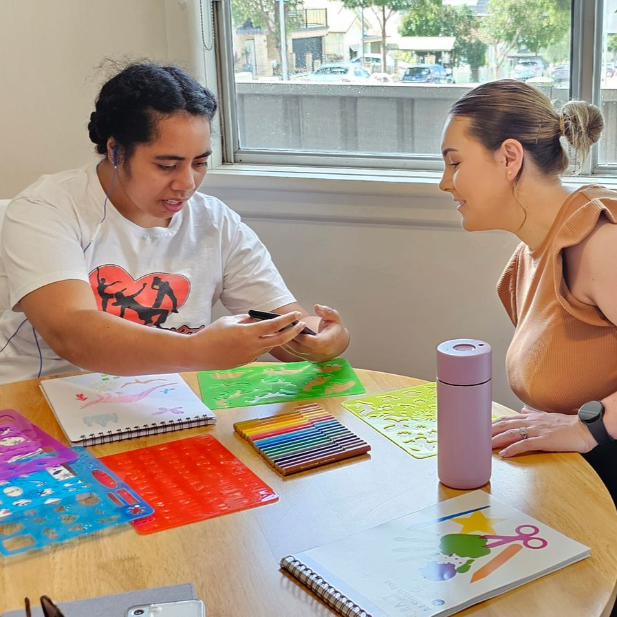 A woman is putting a blanket on an older man in a wheelchair.
