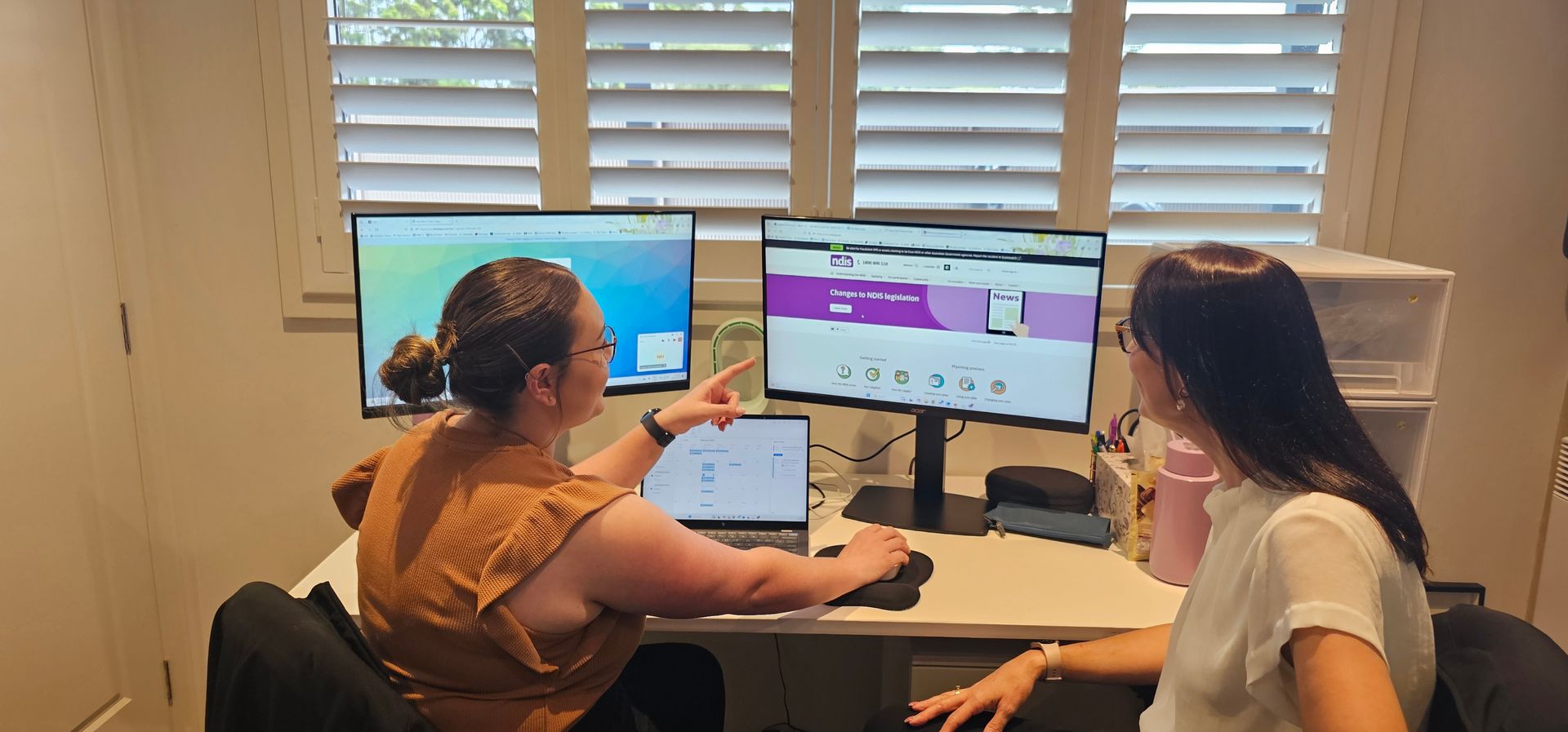 A woman standing in a field with a lake in the background