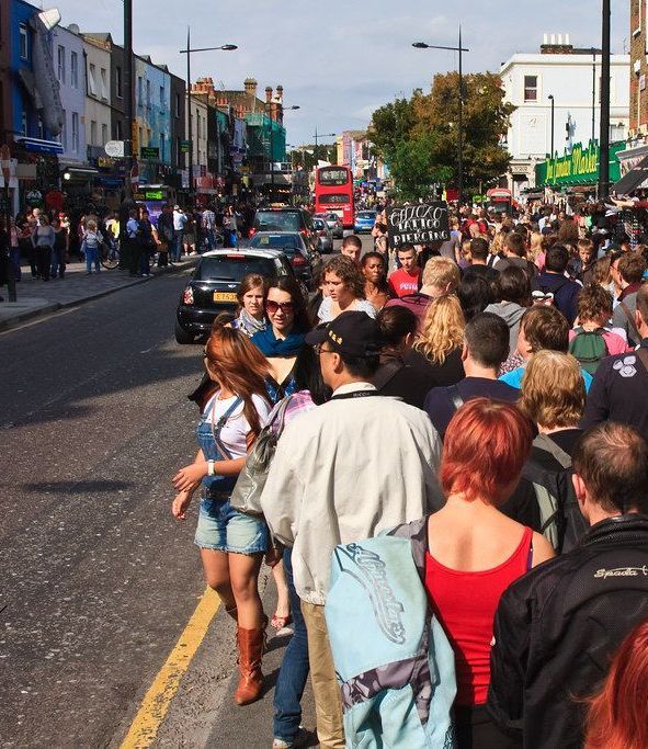 A crowd of people are walking down a busy street