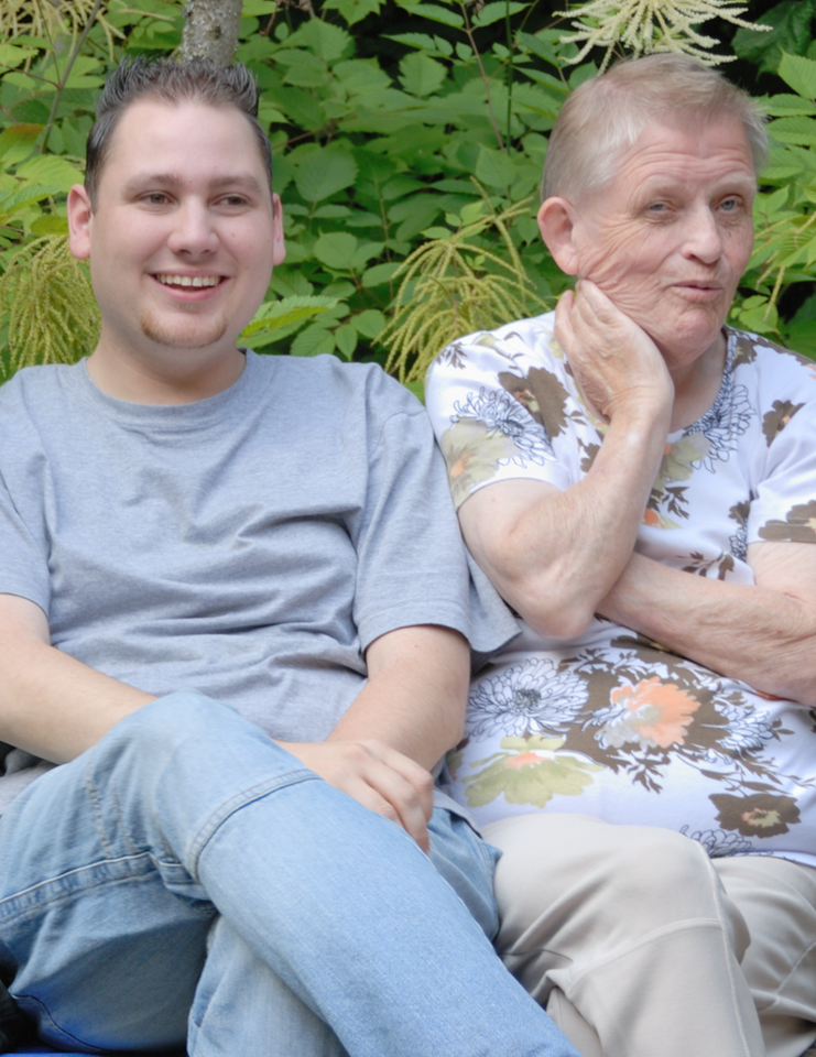 Two men are sitting next to each other with their arms crossed