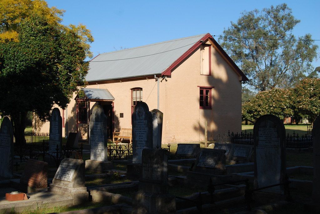 A cemetery with a small building in the background