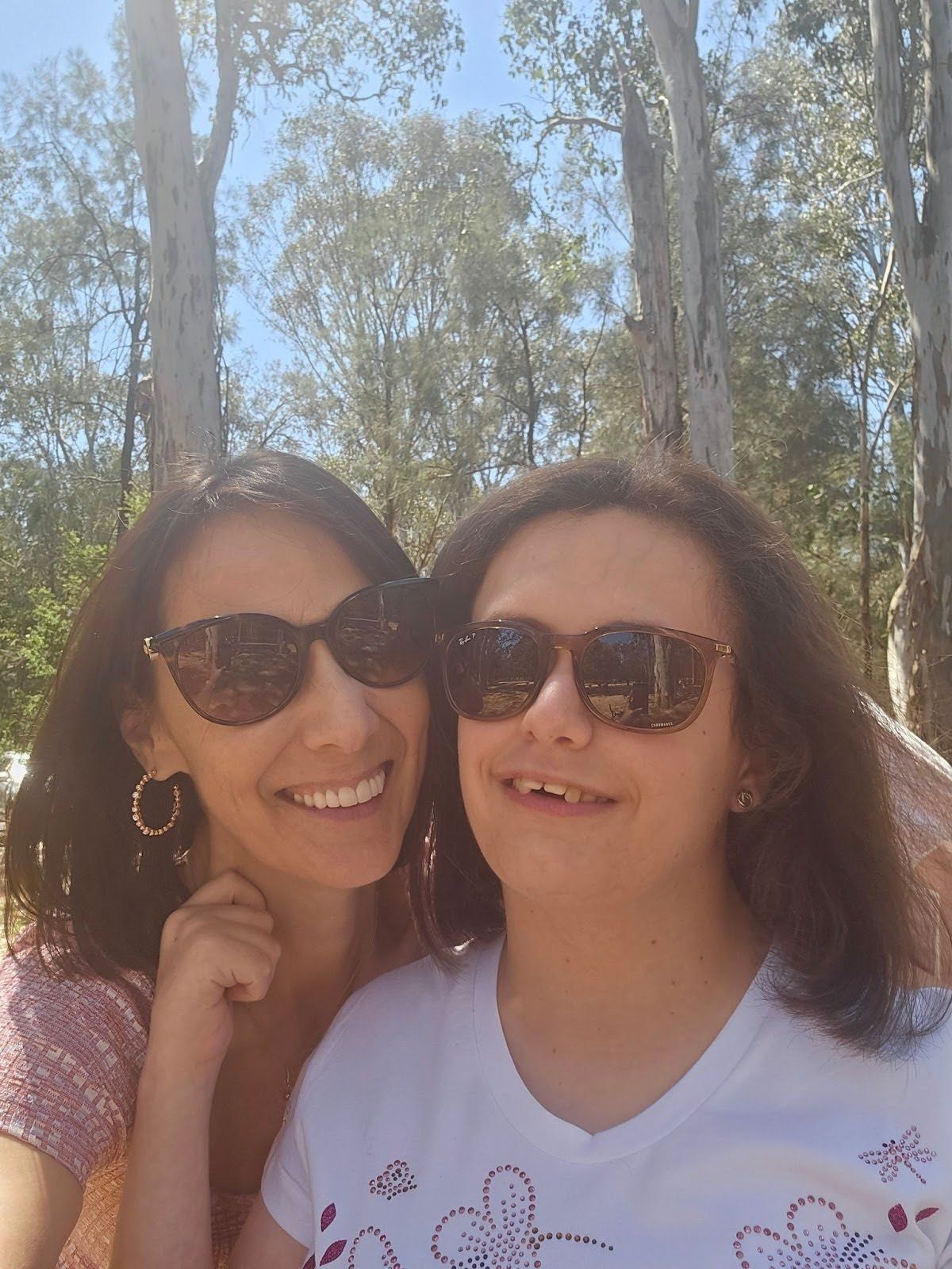 A  women are posing for a picture on the beach