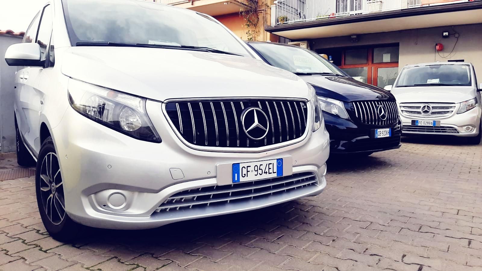 Una fila di furgoni Mercedes sono parcheggiati in un parcheggio.