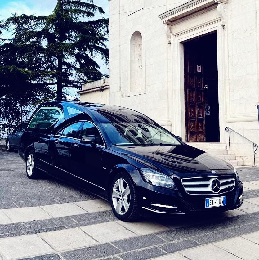 Una mercedes nera è parcheggiata davanti a un edificio
