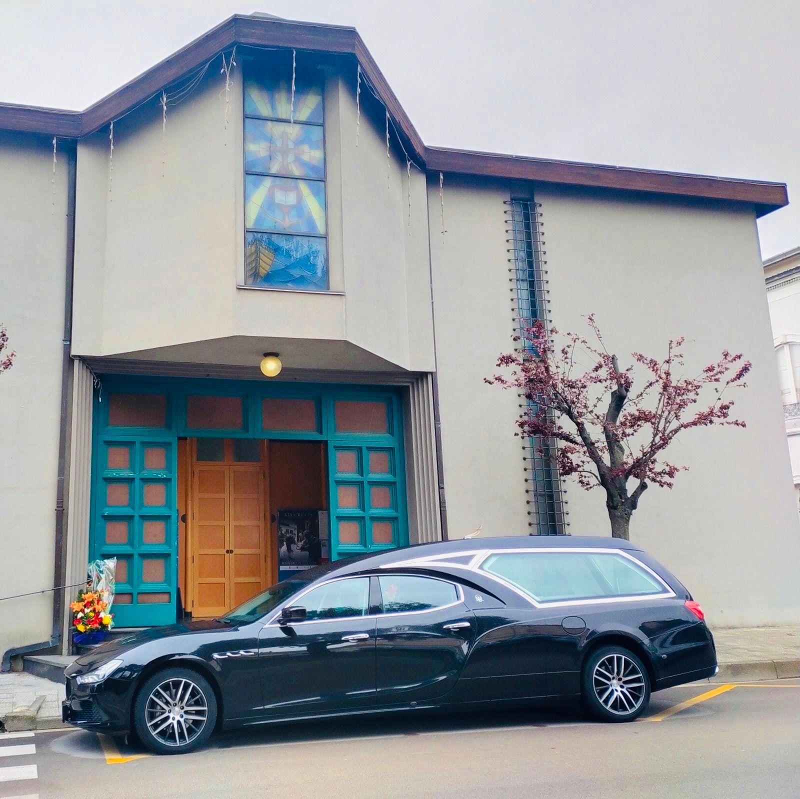 Un'auto nera è parcheggiata davanti a un edificio