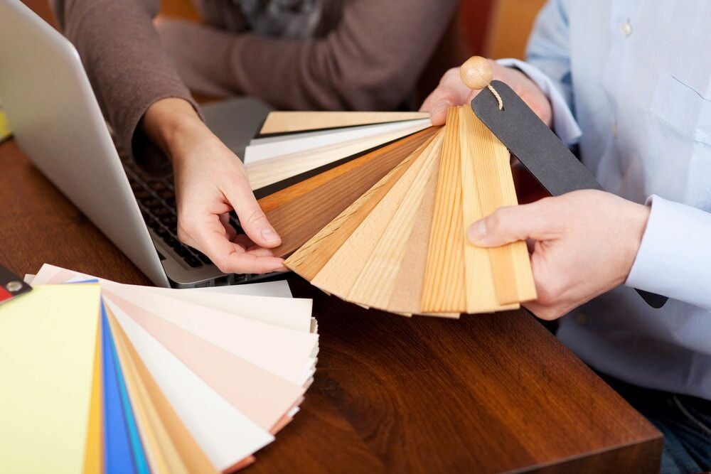 Two People Reviewing Wood and Paint Samples at a Table — KNG Roofing And Construction in Borroloola, NT