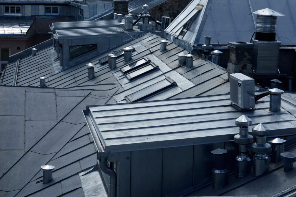 Overhead Shot of Several Grey Metal Roofs With Chimneys and Skylights — KNG Roofing And Construction in Humpty Doo, NT