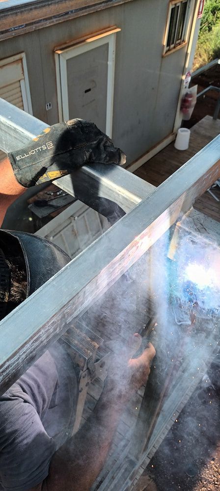A Person Welding Metal on a Building's Exterior — KNG Roofing And Construction in Darwin, NT