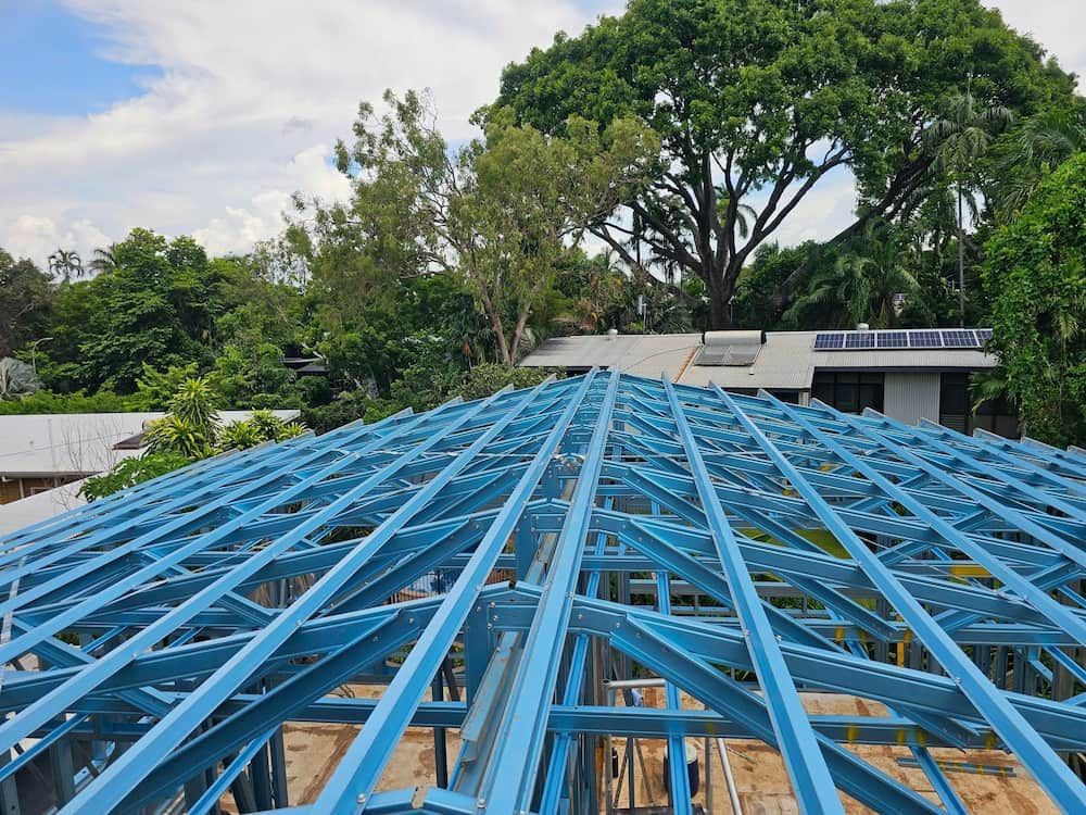Blue Metal Roof Trusses Against a Background of Trees — KNG Roofing And Construction in Darwin, NT
