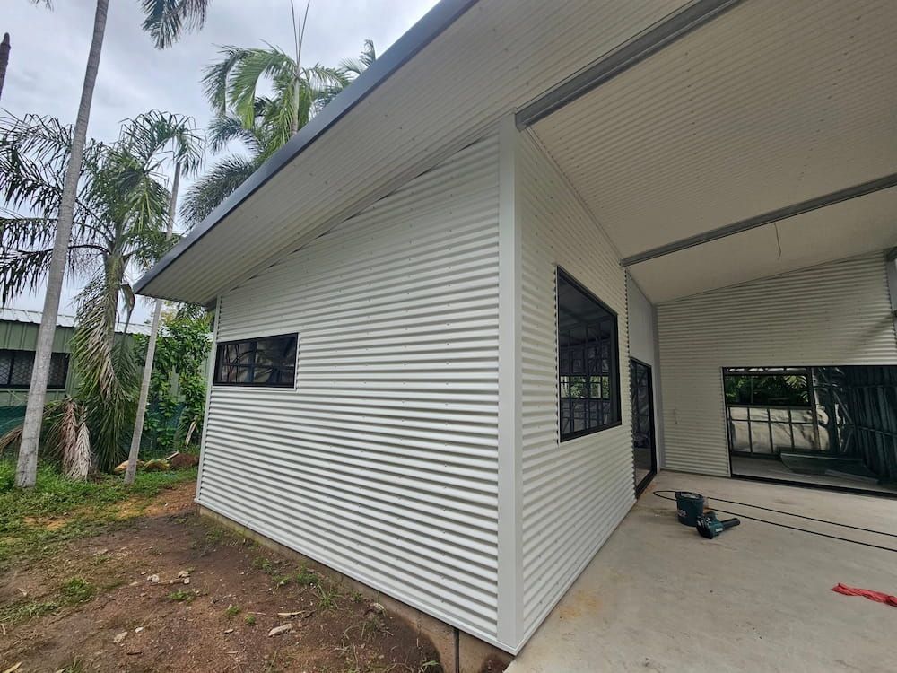 White Corrugated Metal Building With Black Window Frames — KNG Roofing And Construction in Gove, NT