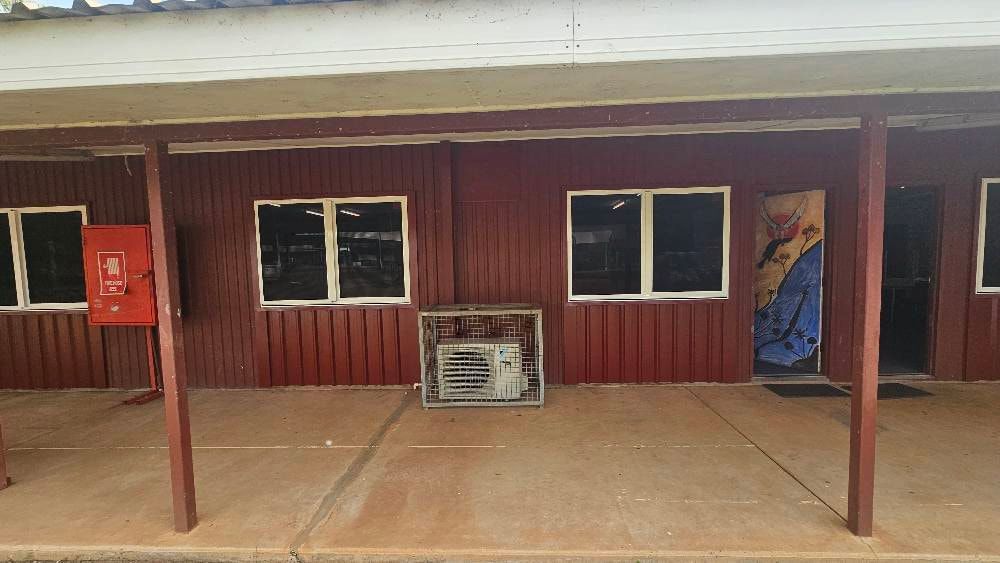 Red Building With Windows, a Fire Box, and an Air Conditioner on a Patio — KNG Roofing And Construction in Darwin, NT