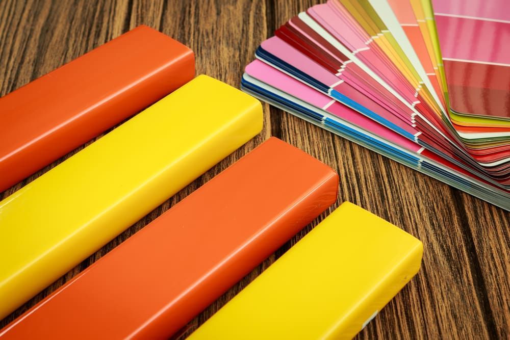 Orange and Yellow Rectangular Objects Next to a Colourful Paint — KNG Roofing And Construction in Maningrida, NT