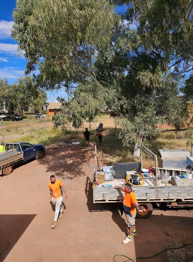Construction Workers Near Parked Trucks Under Trees, Residential Area — KNG Roofing And Construction in Darwin, NT