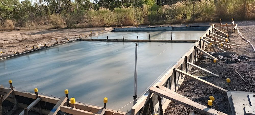 a Rectangular Concrete Foundation Being Constructed Outdoors — KNG Roofing And Construction in Darwin, NT